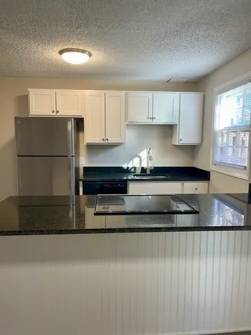 a kitchen with a refrigerator and a stove top oven