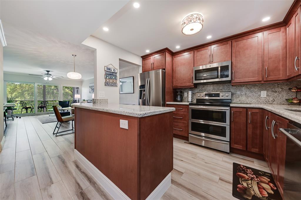 773 Jeffery Street, Unit 4305 Boca Raton, FL 33487 - Photo 4 of 22 a large kitchen with stainless steel appliances and wooden cabinets