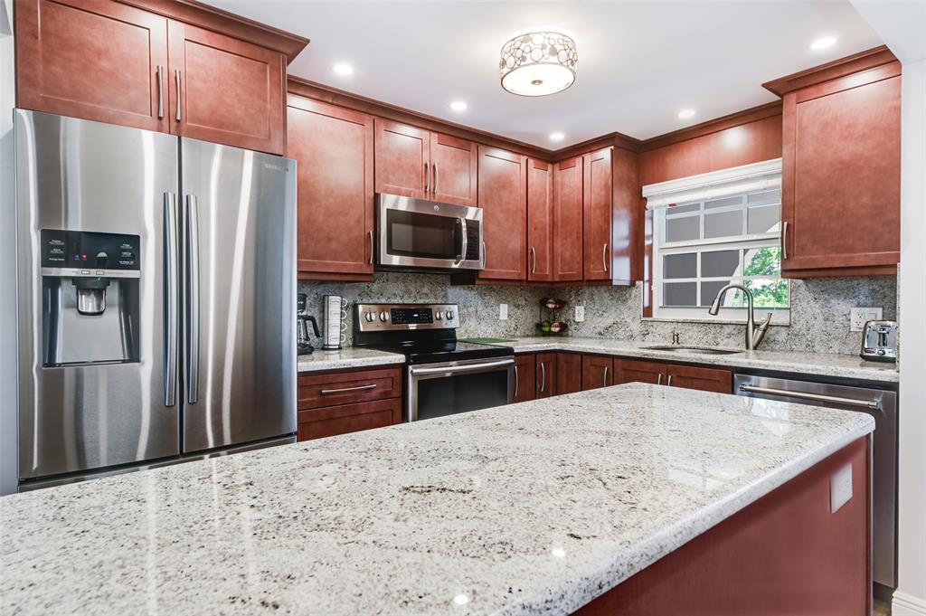 773 Jeffery Street, Unit 4305 Boca Raton, FL 33487 - Photo 5 of 22 a kitchen with stainless steel appliances granite countertop a refrigerator a sink a stove a microwave and wooden cabinets