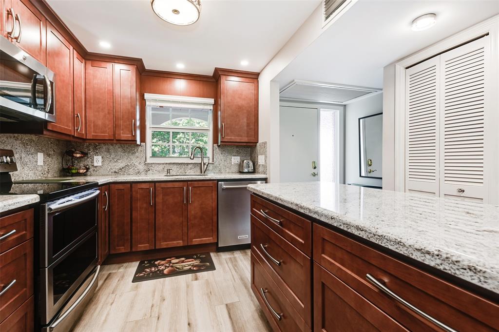 773 Jeffery Street, Unit 4305 Boca Raton, FL 33487 - Photo 6 of 22 a kitchen with granite countertop stainless steel appliances a sink window and cabinets
