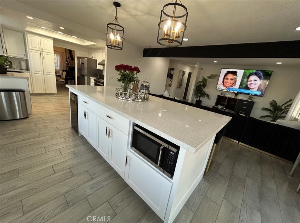 14272 Laurel Drive Riverside, CA 92503 - Photo 6 of 10 a kitchen with stainless steel appliances a stove a microwave oven and a dining table with wooden floor