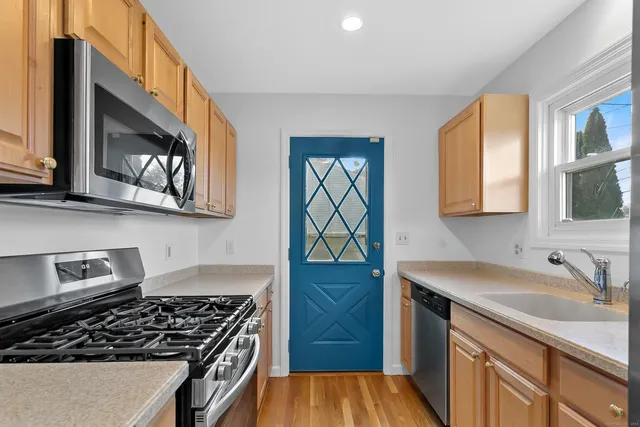 a kitchen with stainless steel appliances a stove a sink and a microwave