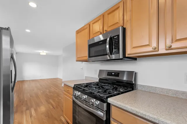 a kitchen with stainless steel appliances granite countertop a stove a microwave and a refrigerator