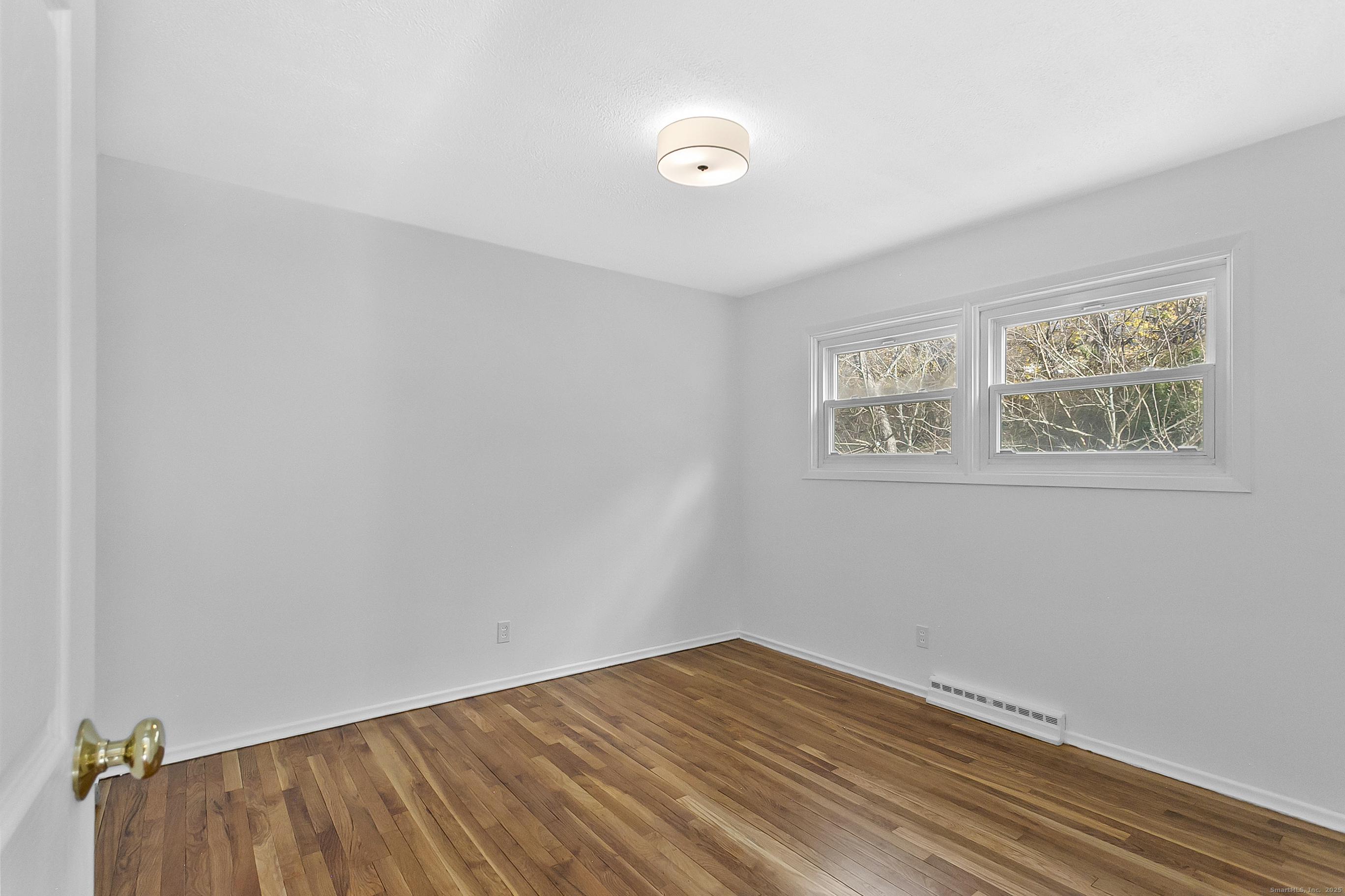 23 Berkshire Road Ansonia, CT 06401 - Photo 20 of 23 a view of an empty room with wooden floor and a window
