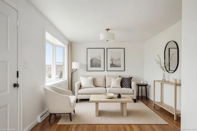 a living room with furniture a table and wooden floor