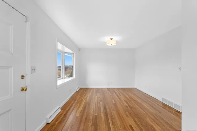 a view of a room with wooden floor and window