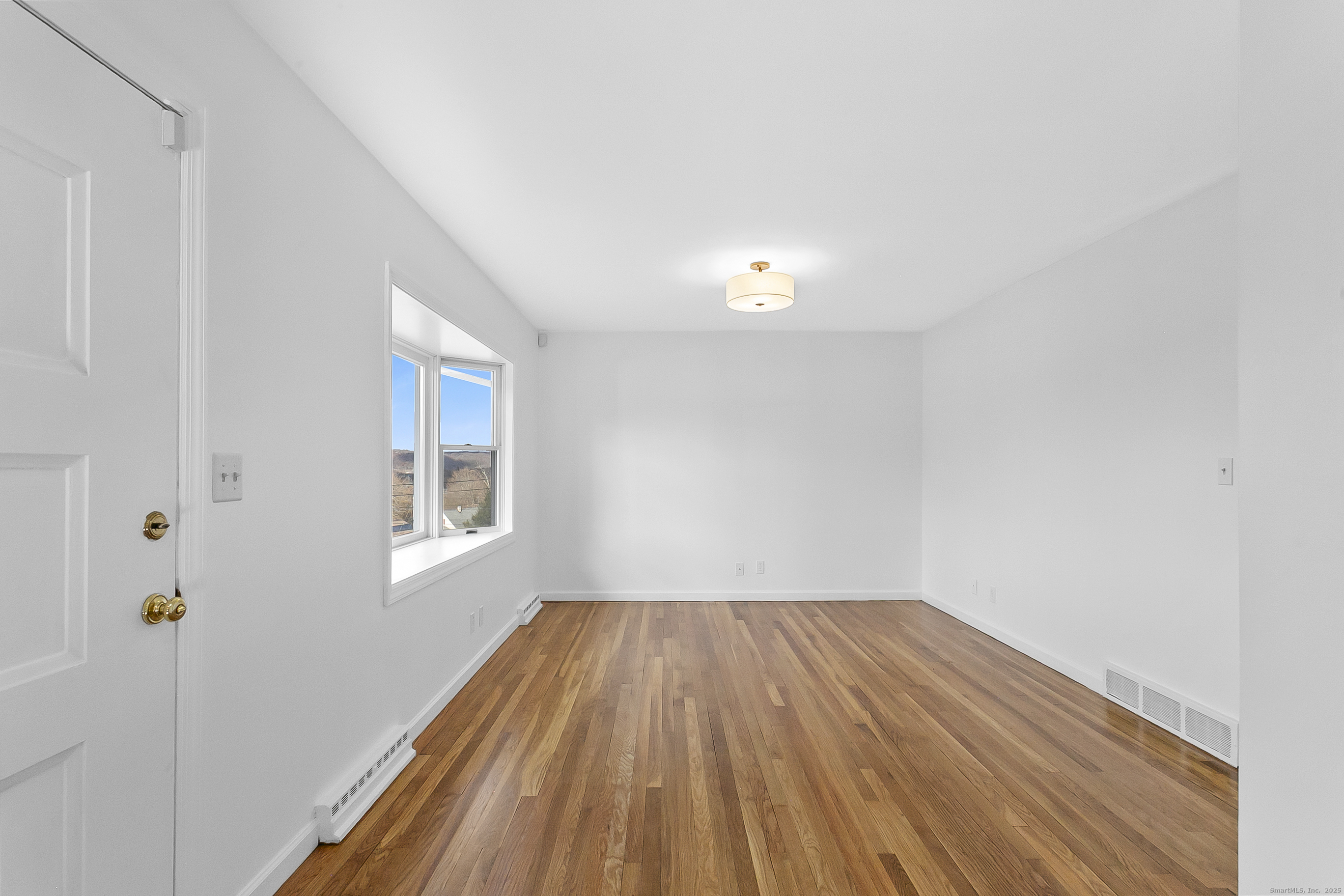 23 Berkshire Road Ansonia, CT 06401 - Photo 4 of 23 a view of a room with wooden floor and window