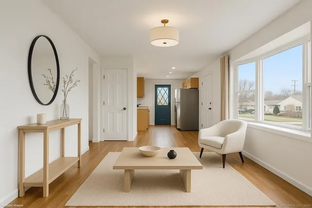 a living room with furniture a table and a large window