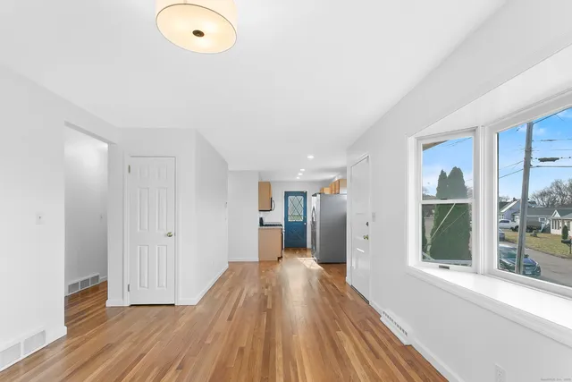 a view of a hallway with wooden floor and staircase
