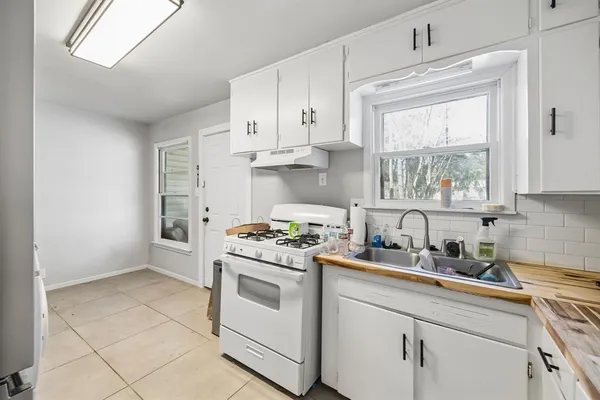 a kitchen with cabinets appliances a sink and a window
