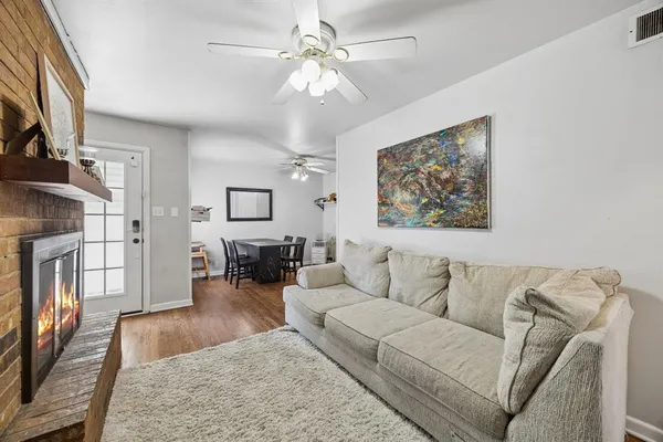 a living room with furniture a fireplace and wooden floor