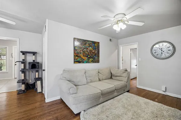 a living room with furniture and a large mirror with wooden floor
