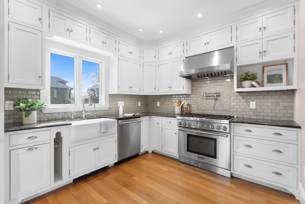 129 High Street Reading, MA 01867 - Photo 11 of 41 a kitchen with stainless steel appliances granite countertop a stove sink and cabinets