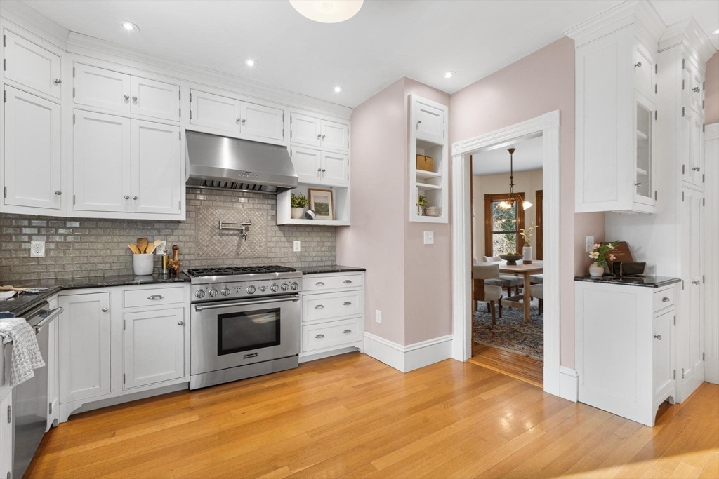 129 High Street Reading, MA 01867 - Photo 13 of 41 a kitchen with stainless steel appliances granite countertop a stove and a sink