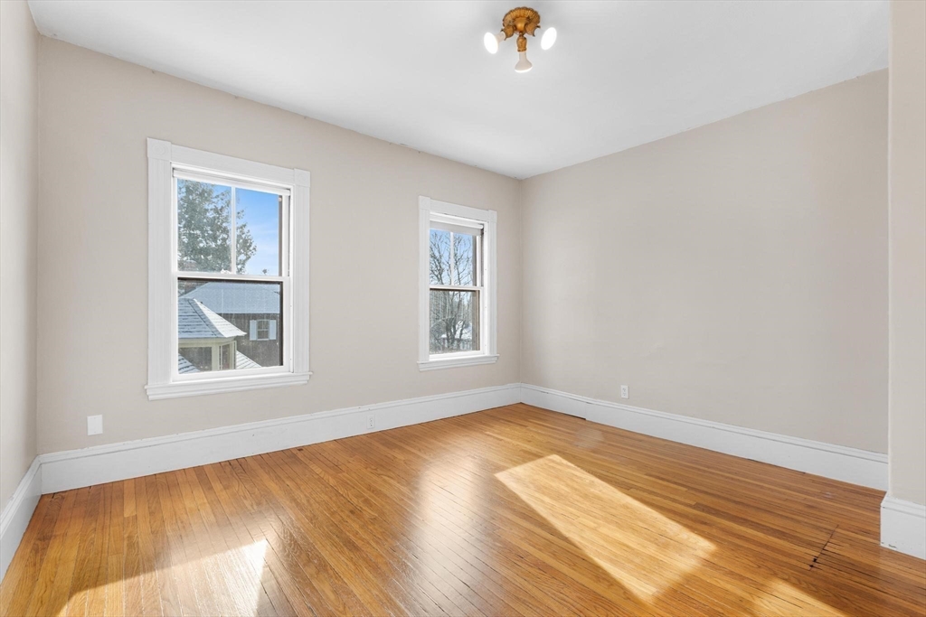 129 High Street Reading, MA 01867 - Photo 20 of 41 a view of an empty room with wooden floor and a window