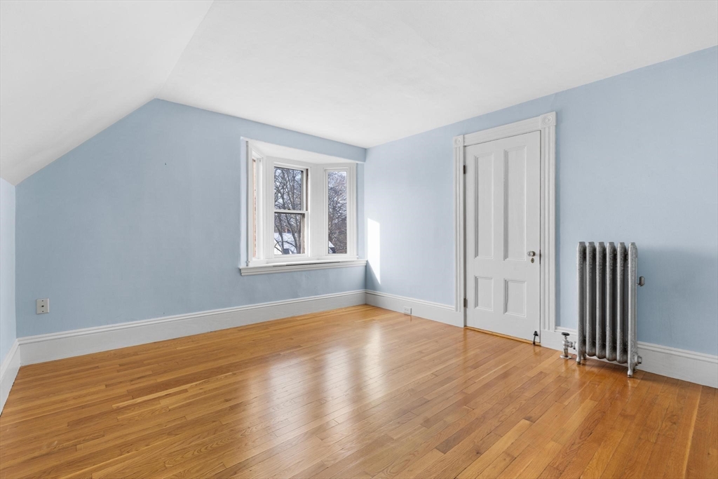 129 High Street Reading, MA 01867 - Photo 23 of 41 a view of an empty room with wooden floor and a window