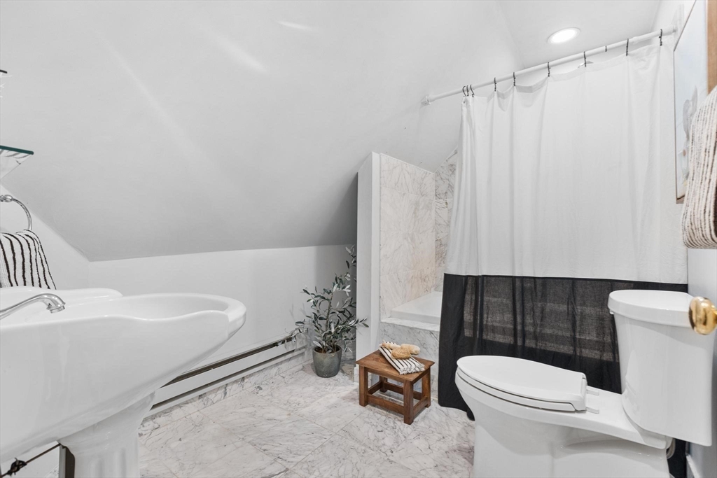 129 High Street Reading, MA 01867 - Photo 26 of 41 a bathroom with a sink a toilet and shower curtain