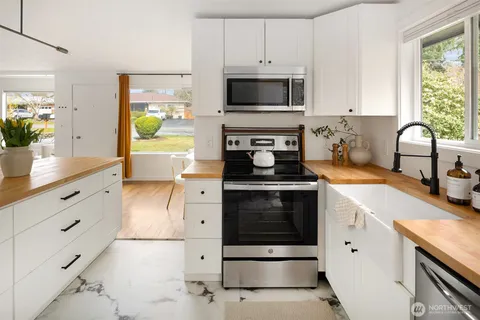 a kitchen with a sink a stove and chairs