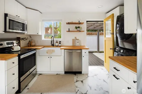 a kitchen with stainless steel appliances a stove microwave and sink