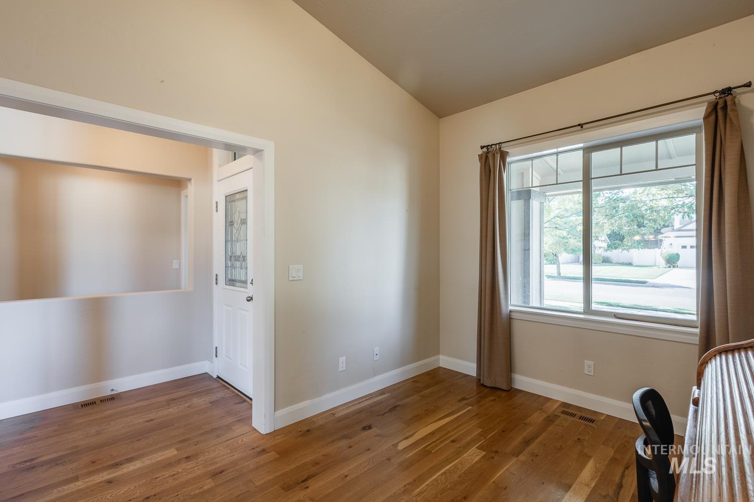 1186 East Observation Street Meridian, ID 83642 - Photo 19 of 33 Room featuring wood-finish flooring, a vaulted ceiling, and an expansive window with upper transom details