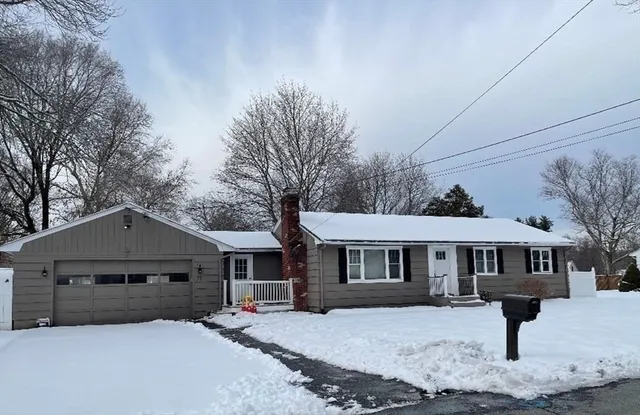 a front view of a house with yard covered in snow