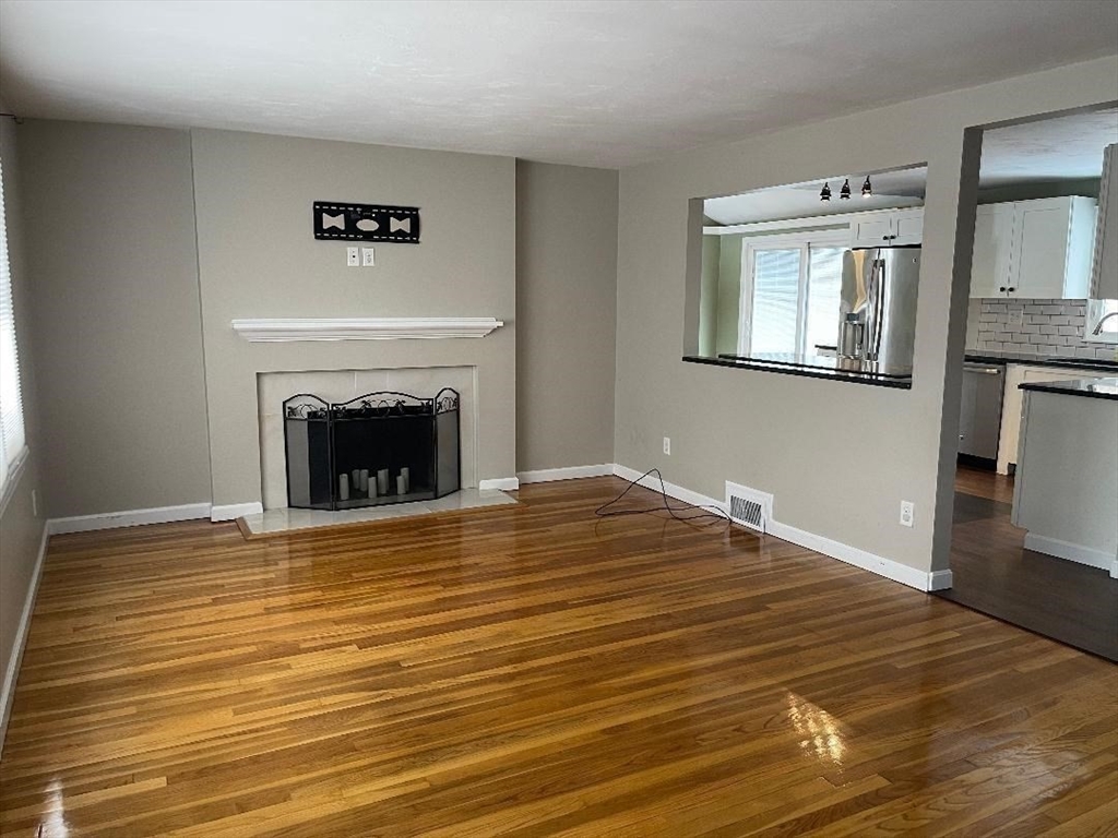 23 Western Avenue West Boylston, MA 01583 - Photo 7 of 18 a view of empty room with wooden floor and fireplace