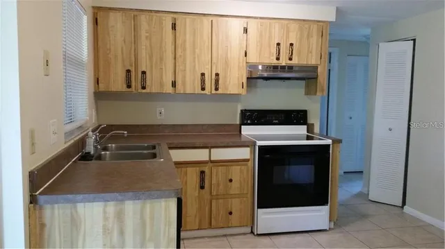 a kitchen with granite countertop a stove and a microwave