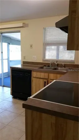 a kitchen with a sink a stove and a window
