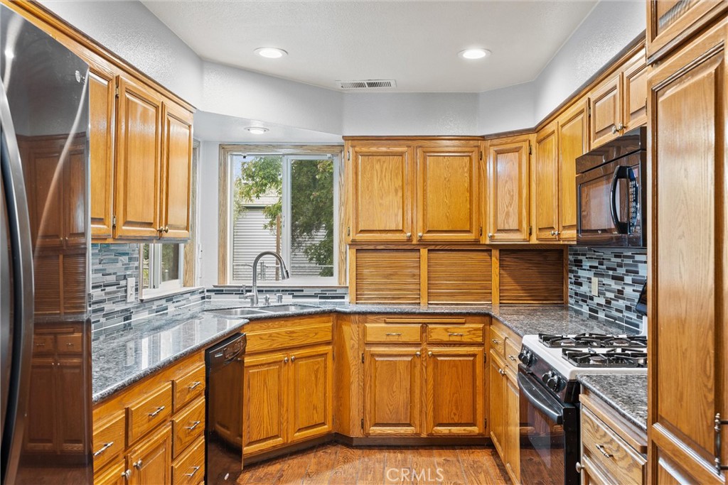 24235 Moon Corning, CA 96021 - Photo 19 of 58 a kitchen with stainless steel appliances granite countertop a stove a sink and a refrigerator