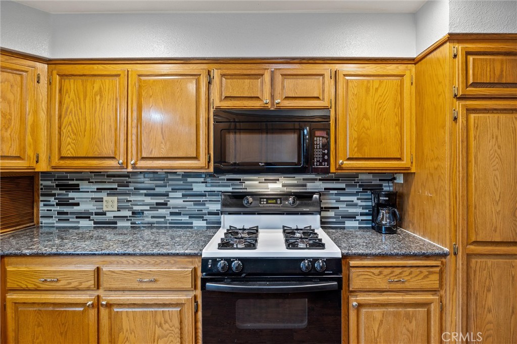 24235 Moon Corning, CA 96021 - Photo 23 of 58 a kitchen with granite countertop a stove and a microwave