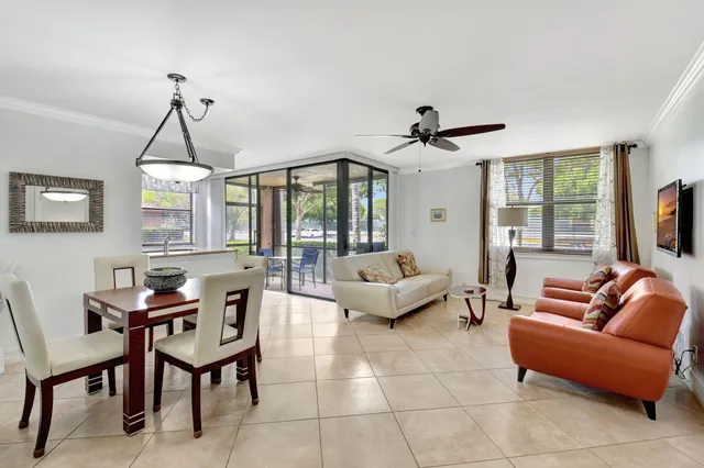 a living room with furniture a ceiling fan a fireplace and a window