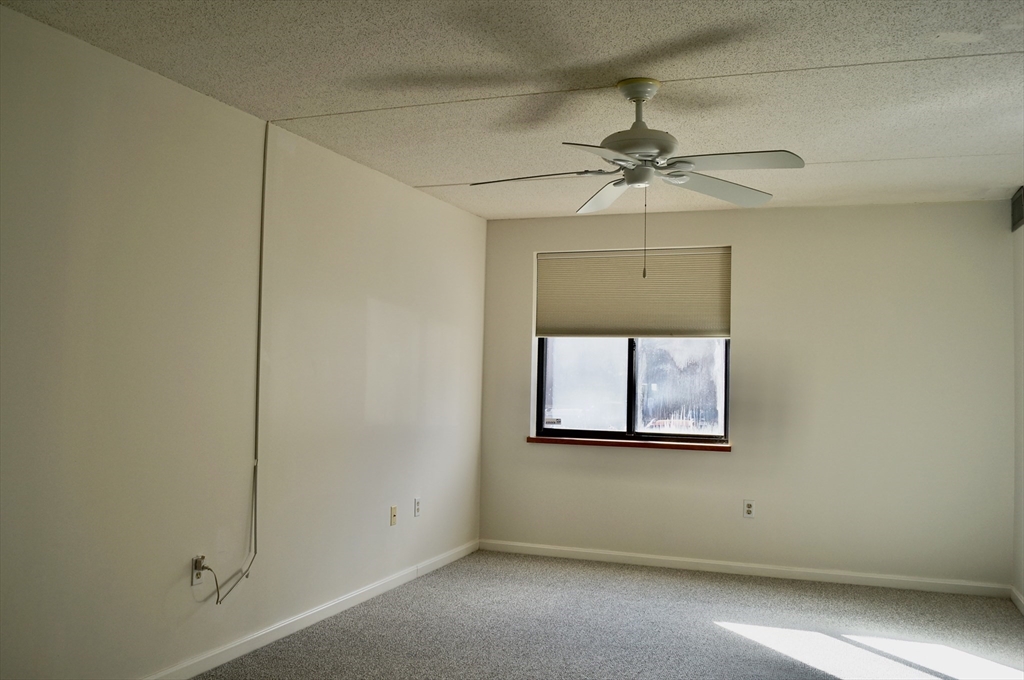 200 Ledgewood Drive, Unit 205 Stoneham, MA 02180 - Photo 12 of 18 an empty room with windows and fan