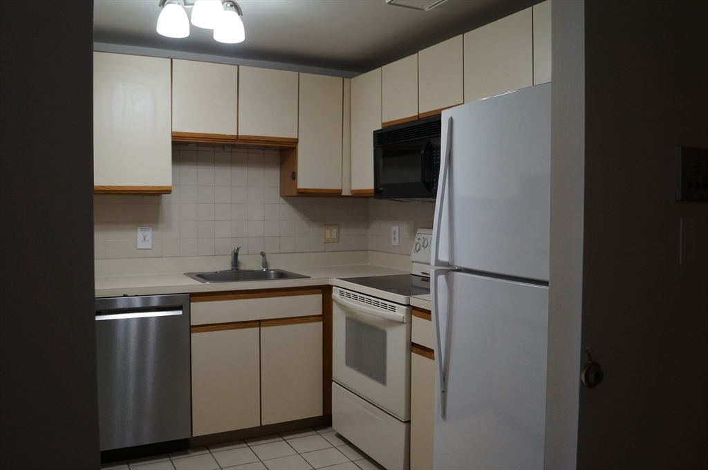 200 Ledgewood Drive, Unit 205 Stoneham, MA 02180 - Photo 4 of 18 a kitchen with a sink and a refrigerator