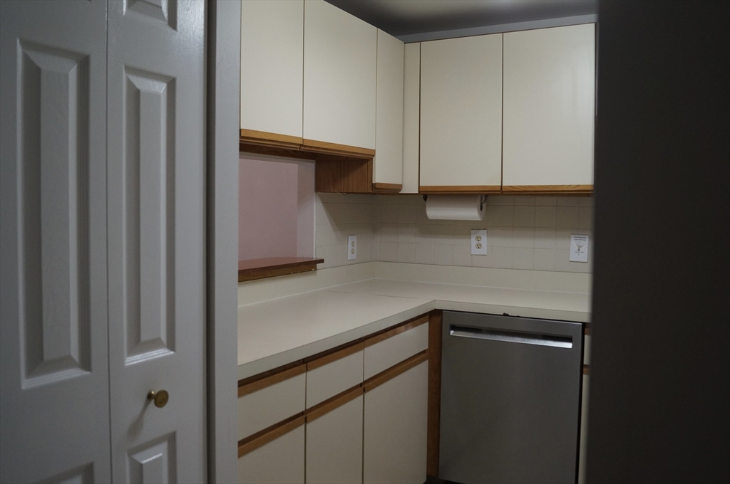 200 Ledgewood Drive, Unit 205 Stoneham, MA 02180 - Photo 6 of 18 a kitchen with a white cabinets and a refrigerator