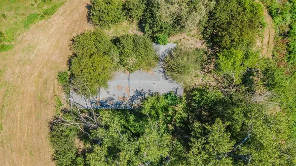 an aerial view of residential house with outdoor space and trees all around