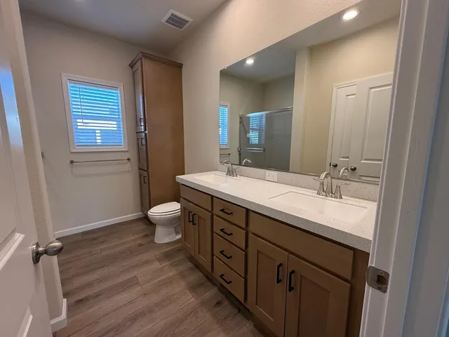 a bathroom with a granite countertop sink toilet a large mirror and shower