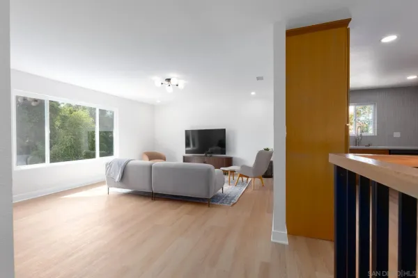 a living room with furniture a flat screen tv and a window