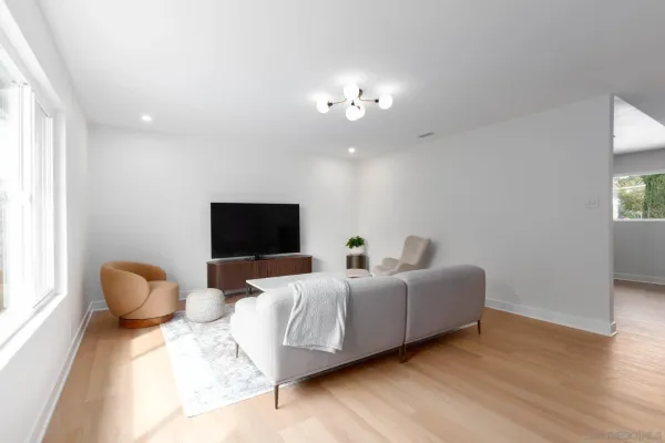 a living room with furniture a chandelier and a flat screen tv