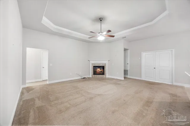 an empty room with a ceiling fan and a fireplace