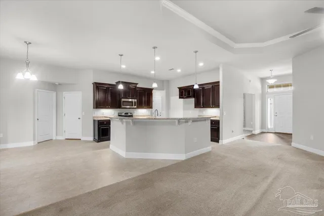a view of kitchen with stainless steel appliances kitchen island granite countertop a stove top oven and a sink