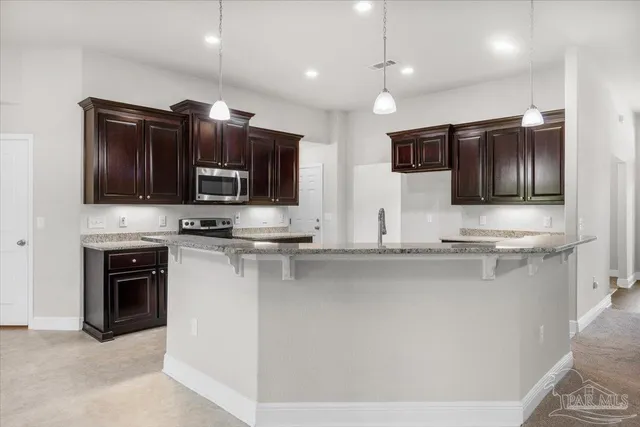a kitchen with stainless steel appliances wooden cabinets a sink and a stove