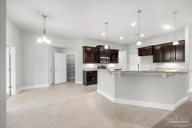 a large kitchen with stainless steel appliances kitchen island a large counter top space a center island a stove cabinets and a kitchen island