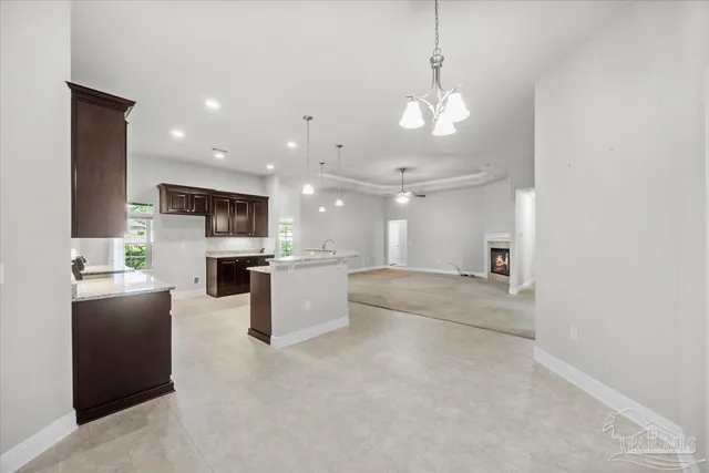 a view of a kitchen with kitchen island a sink stainless steel appliances and cabinets