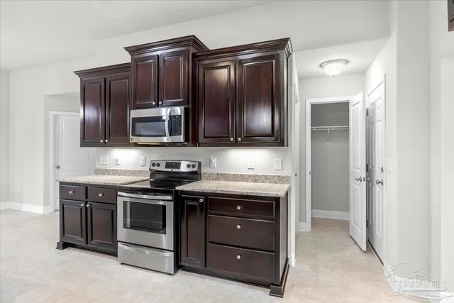 a kitchen with granite countertop stainless steel appliances and wooden cabinets