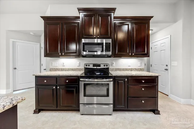 a kitchen with granite countertop stainless steel appliances and cabinets