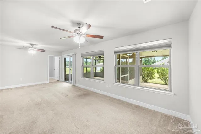 a view of a big room with a ceiling fan and a bathroom