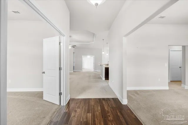 a view of a room with wooden floor and a bathroom