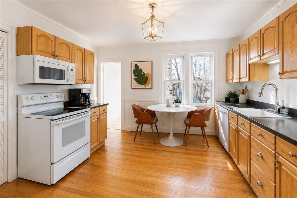 215 Ash Street, Unit 3 Waltham, MA 02453 - Photo 12 of 18 a large kitchen with stainless steel appliances granite countertop a stove a sink and a microwave