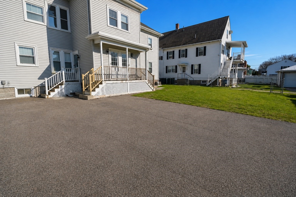 215 Ash Street, Unit 3 Waltham, MA 02453 - Photo 15 of 18 a view of a house with a yard next to a road