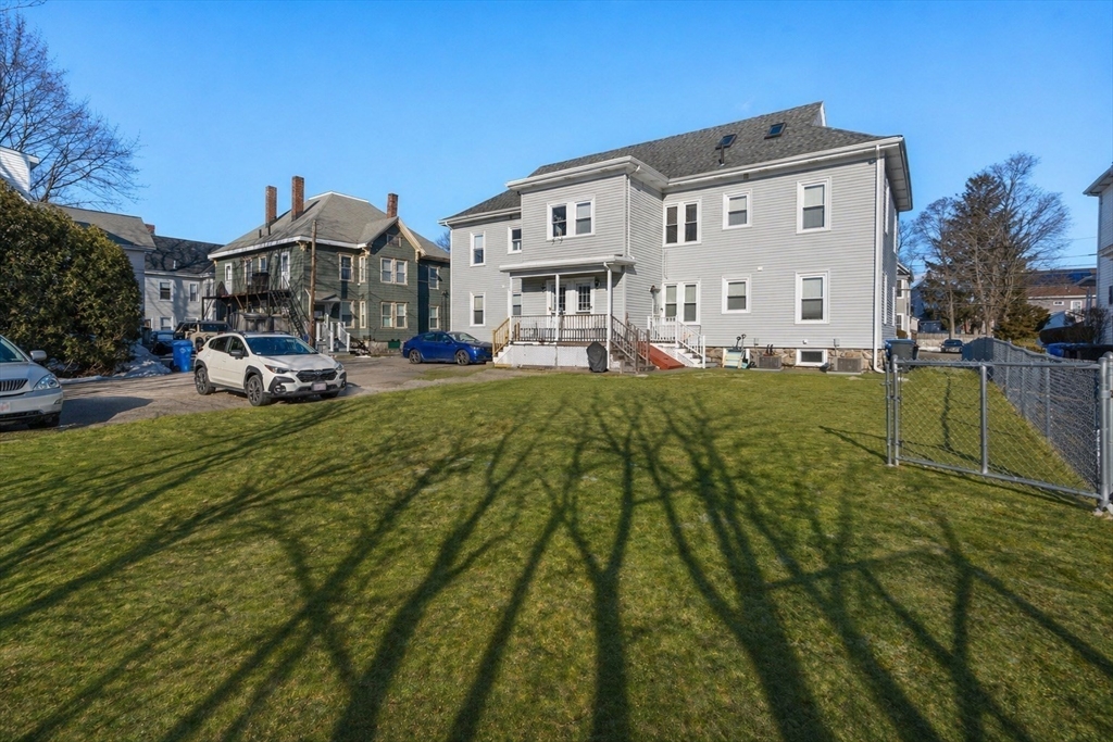 215 Ash Street, Unit 3 Waltham, MA 02453 - Photo 16 of 18 a front view of a house with a garden and deck